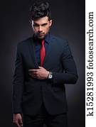 business man holds hand on suit lapel