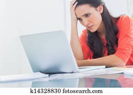Confused designer looking at her laptop Confused designer looking at her laptop