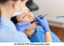 Dentist Examining MID Adult Patient's Mouth In Clinic Dentist Examining MID Adult Patient's Mouth In Clinic