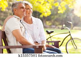 elegant mid age couple daydreaming retirement outdoors elegant mid age couple daydreaming retirement outdoors