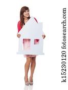 Elegant young woman holding house sign