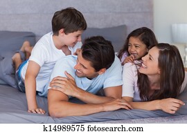 familia feliz, tener diversión, en la cama