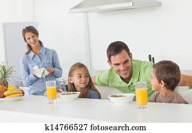 Father speaking to his children who are having breakfast