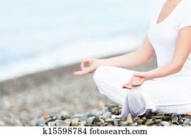 hand of  woman meditating in a yoga pose on beach