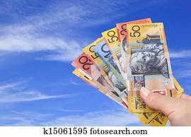 Handful of Australian Money over Blue Sky.