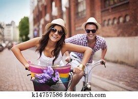 Happy couple cycling in the city Happy couple cycling in the city