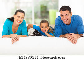 happy family lying on bed with pet dog