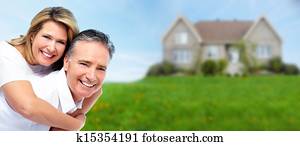 Happy senior couple near new house.