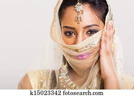 indian woman in sari costume covering her face