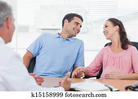 Loving couple expecting baby consulting doctor