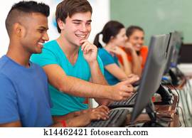 male high school student helping classmate with computer male high school student helping classmate with computer