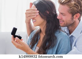 Man hiding his wife's eyes to offer her an engagement ring Man hiding his wife's eyes to offer her an engagement ring