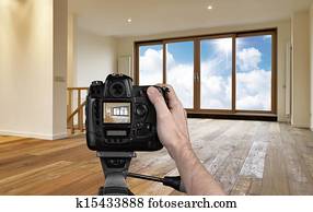 Man photographing empty living room with digital camera