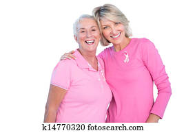 Mature women wearing pink tops and ribbons for breast cancer