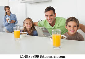 Portrait of a father and his children having breakfast