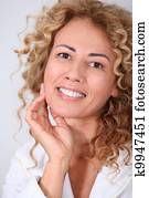 Portrait of beautiful woman looking at wrinkles in mirror