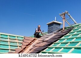 Roofer hammering nails on the beams