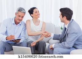 Salesman closing a deal with a couple Salesman closing a deal with a couple