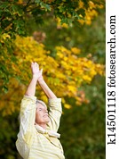 Senior Woman Doing Stretching Exercise In Park