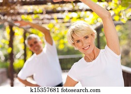 senior woman exercising with husband outdoors