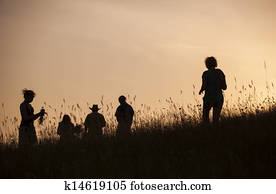Silhouettes of People picking flowers during midsummer soltice 