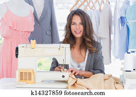 Smiling fashion designer using sewing machine Smiling fashion designer using sewing machine