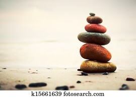 Stones pyramid on sand symbolizing zen, harmony, balance