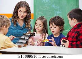 Teacher Teaching Students To Play Xylophone In Class Teacher Teaching Students To Play Xylophone In Class