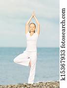 woman in white doing yoga on  beach