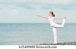 woman in white doing yoga on  beach
