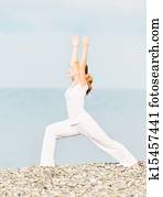 woman in white doing yoga on  beach
