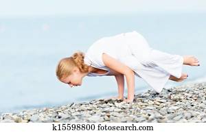 woman in white doing yoga on  beach