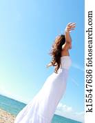 Woman relaxing at the beach with arms open