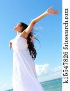 Woman relaxing at the beach with arms open enjoying her freedom