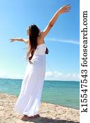Woman relaxing at the beach with arms open enjoying her freedom