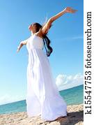 Woman relaxing at the beach with arms open enjoying her freedom