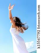 Woman relaxing at the beach with arms open enjoying her freedom