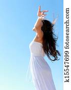 Woman relaxing at the beach with arms open enjoying her freedom