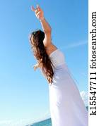 Woman relaxing at the beach with arms open enjoying her freedom
