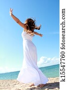 Woman relaxing at the beach with arms open enjoying her freedom
