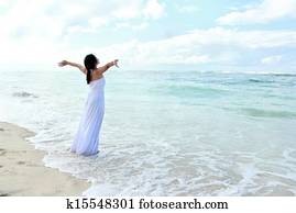Woman relaxing at the beach with arms open