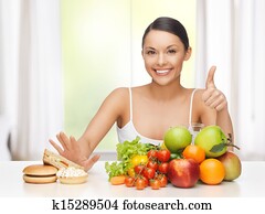 woman with fruits rejecting junk food woman with fruits rejecting junk food