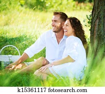 Young Couple Having Picnic in a Park. Happy Family Outdoor Young Couple Having Picnic in a Park. Happy Family Outdoor