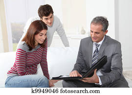 Young couple signing renting contract with real estate agent
