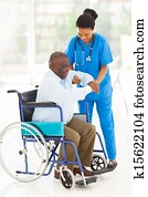 african caregiver helping senior man getting up african caregiver helping senior man getting up