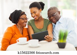 african family at home using tablet pc