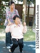 Asian senior women playing swing at outdoor garden park