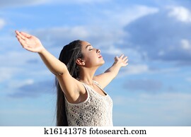 Beautiful arab woman breathing fresh air with raised arms