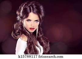 Beauty Model Woman with Professional Makeup. Hairstyle. Stylish Haircut. Fringe. Glossy Curly Hair. Extensions. Fashion Girl. Hair Coloring