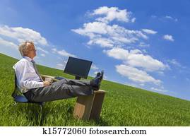 Businessman Relaxing Thinking At Desk in Green Field
